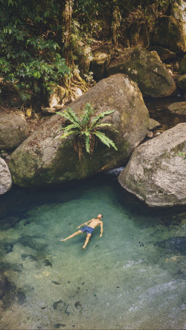 Man floating upside down in a natural pool